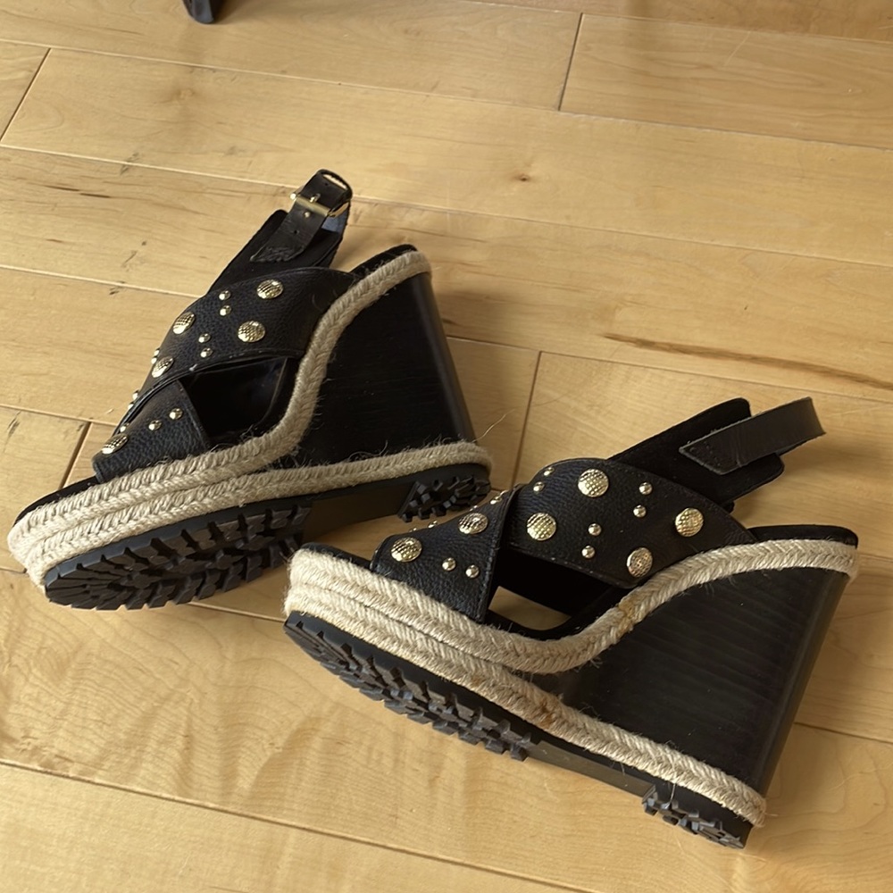 Black wedge shoes with rope and gold-tone stud details.